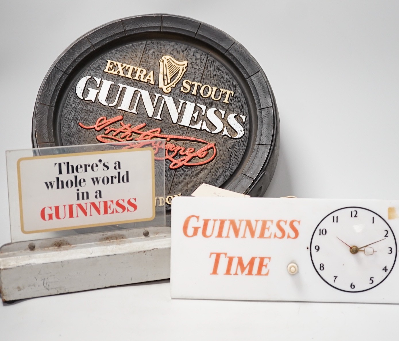 A Guinness time illuminating timepiece, Guinness display light and a Guinness advertising barrel cover